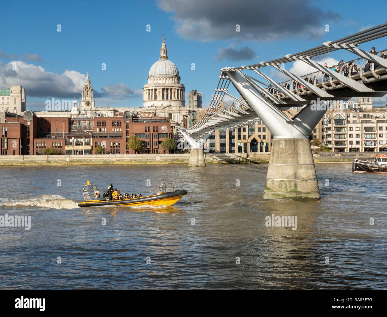 Crociera turistica in motoscafo giallo vuoto lungo il Tamigi verso il Millennium Bridge di Londra con la cattedrale di St Paul sullo sfondo. Foto Stock
