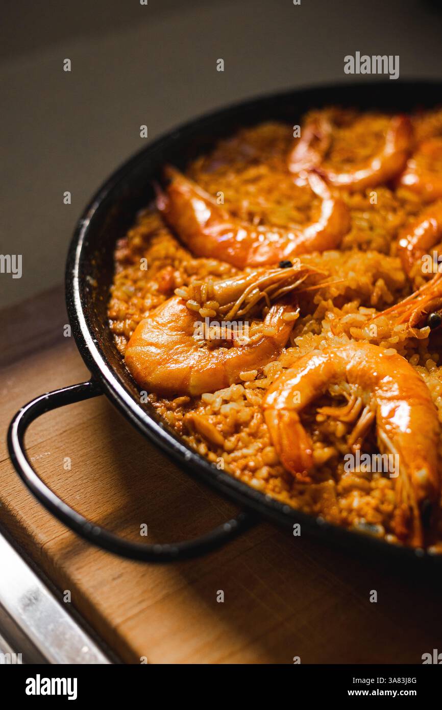 Una paella spagnola fatta in casa in una padella di ferro Foto Stock