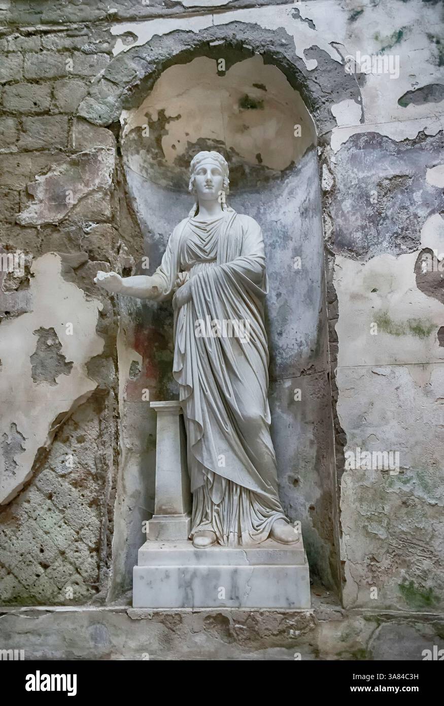 CASERTA, ITALIA - 1° APRILE 2024: Statua in marmo intemprato che si erge elegantemente tra le mura decadenti della Reggia di Caserta Foto Stock