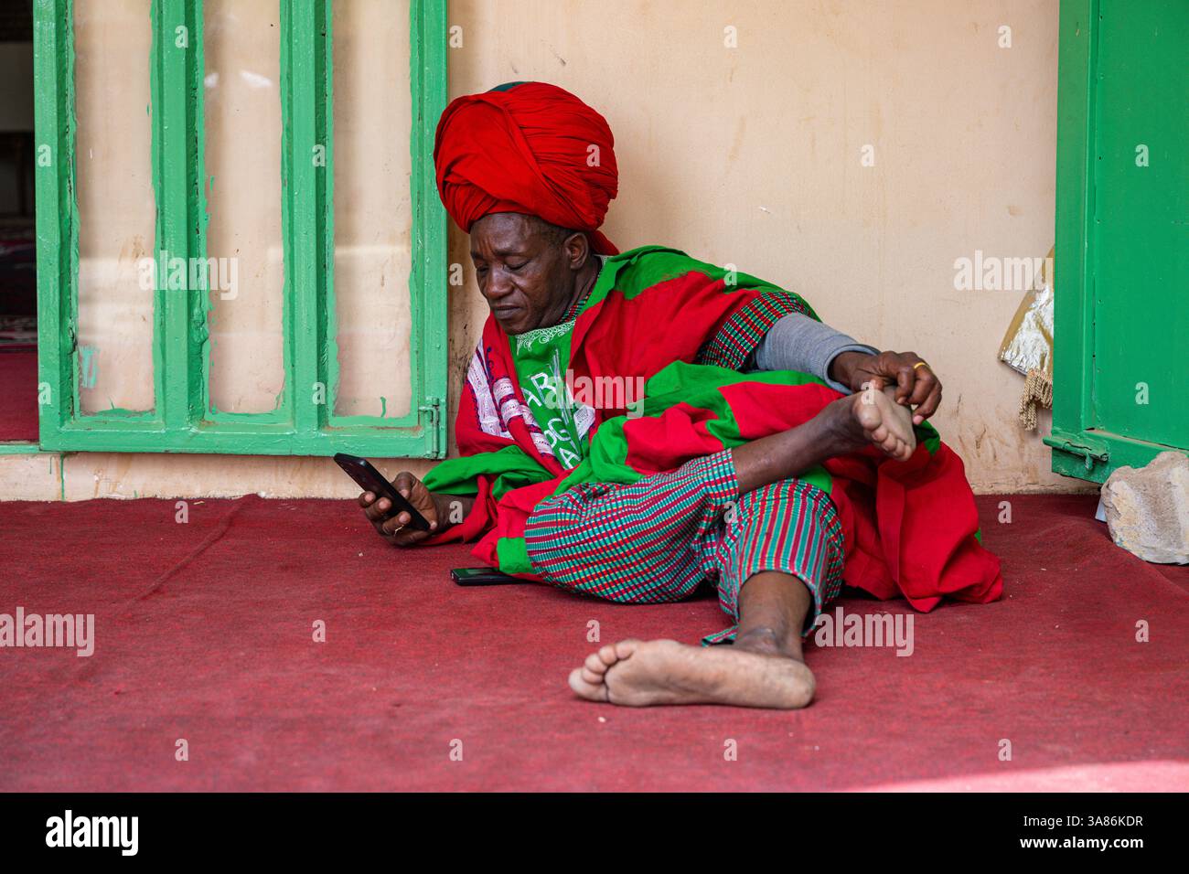 Guardia del corpo annoiata nel palazzo dell'Emiro Fadar Daurama, l'Emirato Daura, lo stato di Katsina, Nigeria Foto Stock