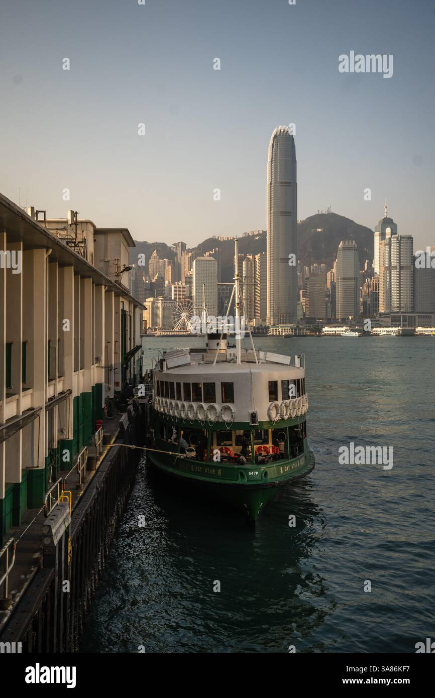 Immagine verticale di un traghetto Star attraccato con lo skyline di Hong Kong sullo sfondo, Hong Kong, Cina Foto Stock
