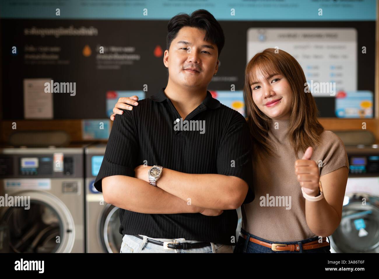 Giovane coppia asiatica fiduciosa nel negozio di lavanderia Foto Stock