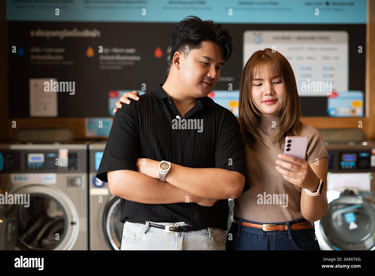 Giovane coppia asiatica fiduciosa nel negozio di lavanderia Foto Stock