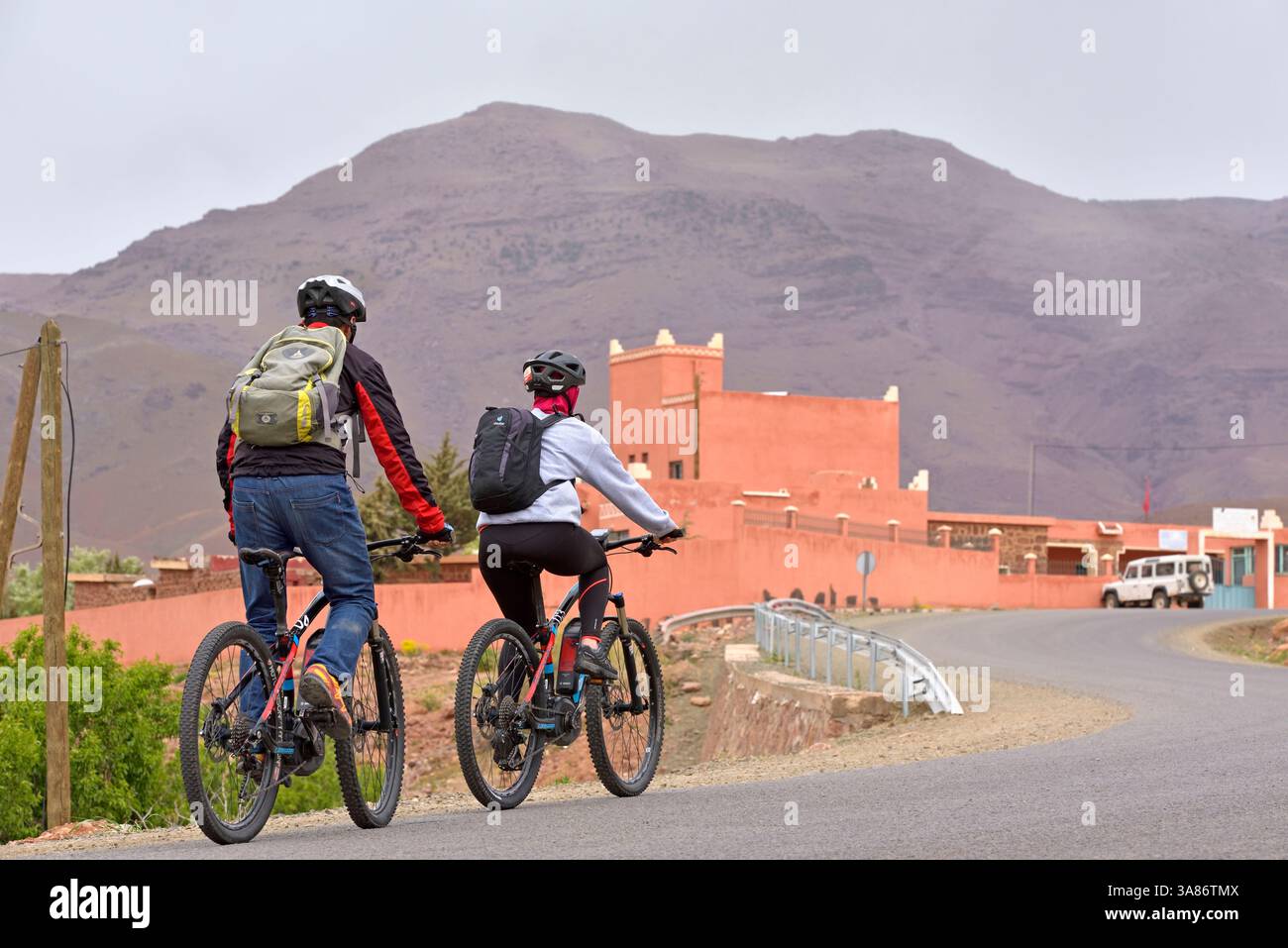 Ciclisti con pedalata di montagna su strada che collega il passo tizi n'Tichka al villaggio di Telouet, provincia di Ouarzazate, regione di Draa-Tafilalet, Marocco Foto Stock