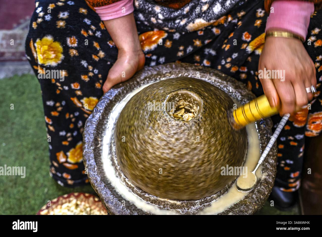 Donna che produce olio di argan a Medina, Marrakech, Marocco Foto Stock