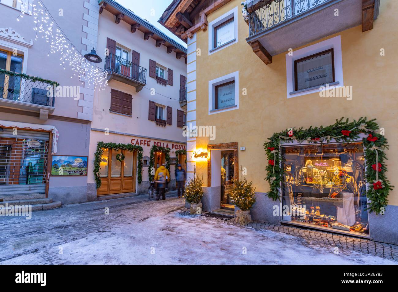Vista dei negozi del centro città sulla neve a Courmayeur al crepuscolo durante il Natale, Courmayeur, Valle d'Aosta, Alpi italiane, Italia Foto Stock