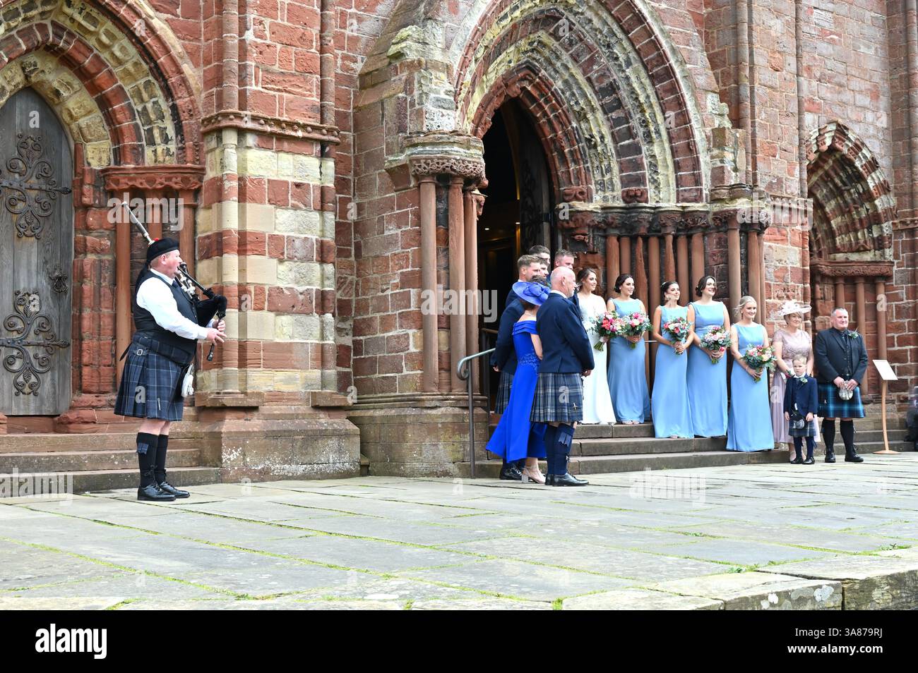 Festa di nozze e pifferaio nelle Highland, nella Cattedrale di San Magnus, Kirkwall, Orcadi, Scozia Foto Stock