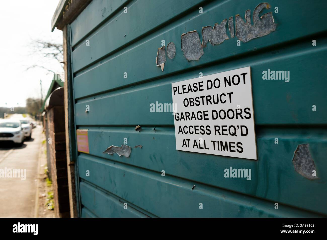 Non ostruire il cartello della porta del garage su una porta del garage usurata Foto Stock