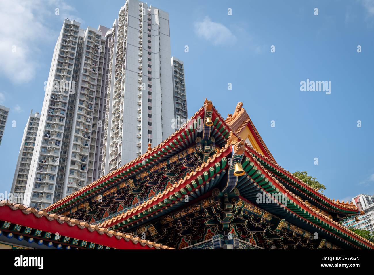 Dettagli di architettura tradizionale Cinese con elementi complessi colorati in contrasto con moderni blocchi di alti appartamenti. Foto Stock