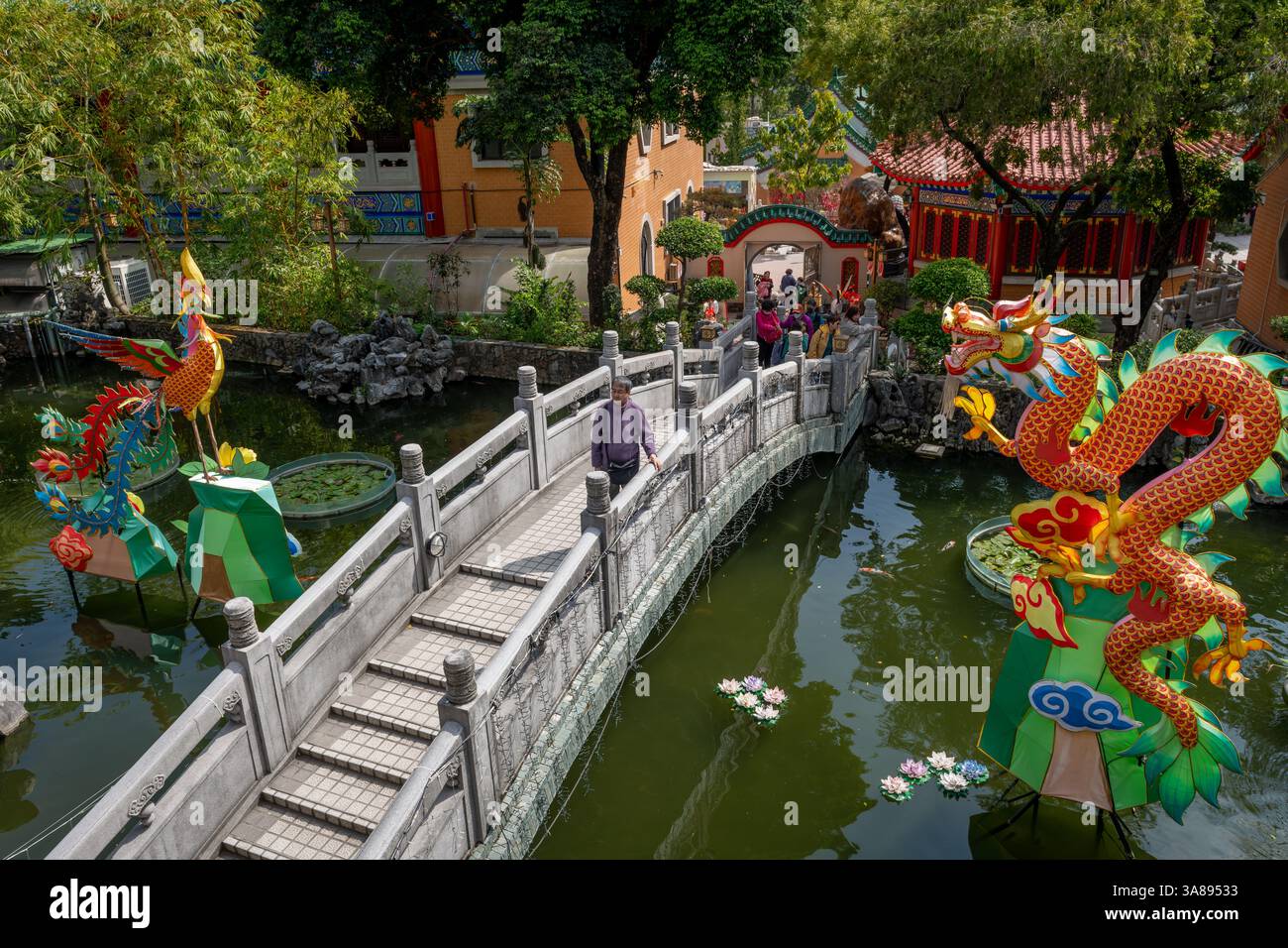 Hong Kong. Cina- 02.24.2025.Vista ad alto angolo del tradizionale ponte in pietra cinese e del drago, phoenix, installazione sullo stagno del buon desiderio Foto Stock