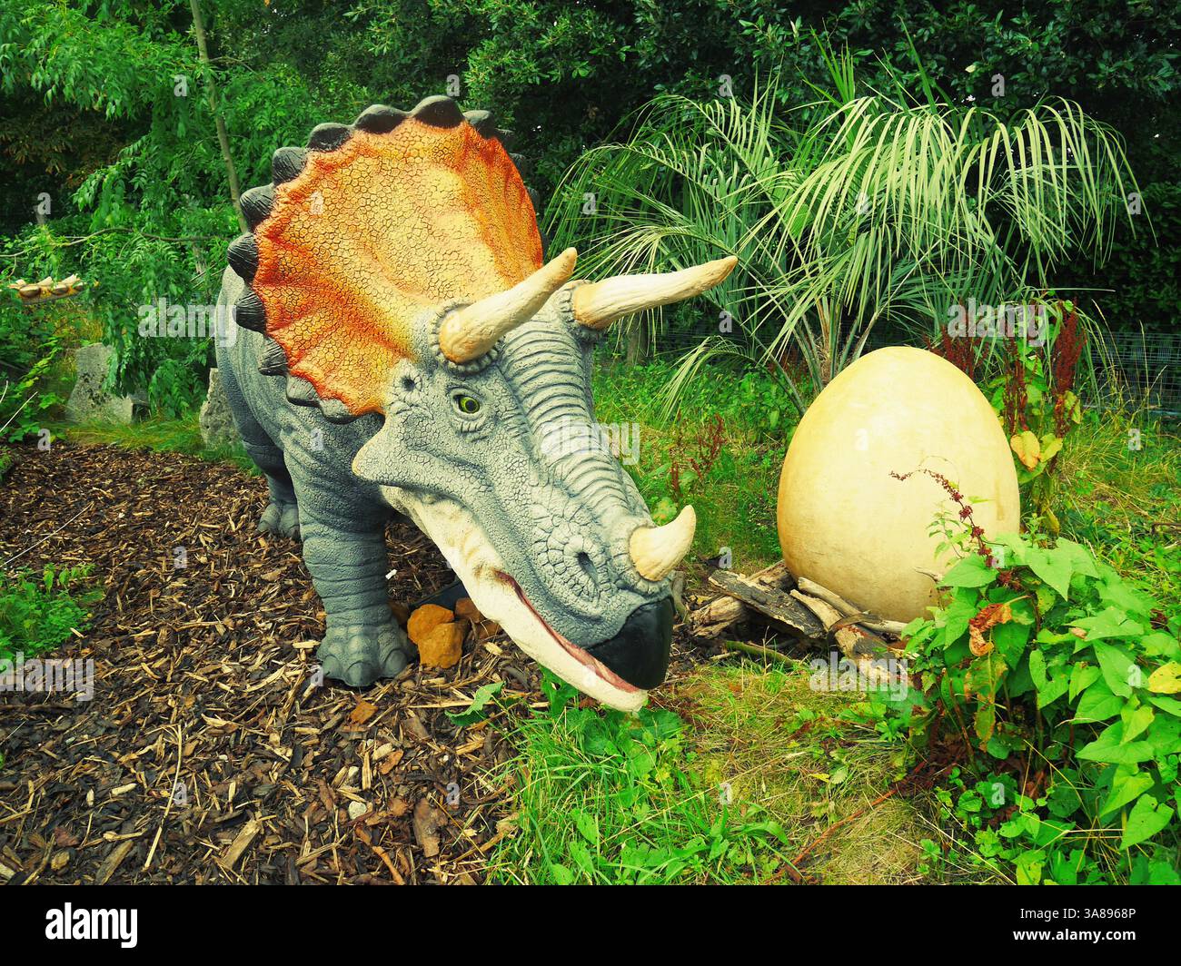 Una foto colorata di un triceratops e un modello di uovo di dinosauro nello zoo di Londra. Foto Stock
