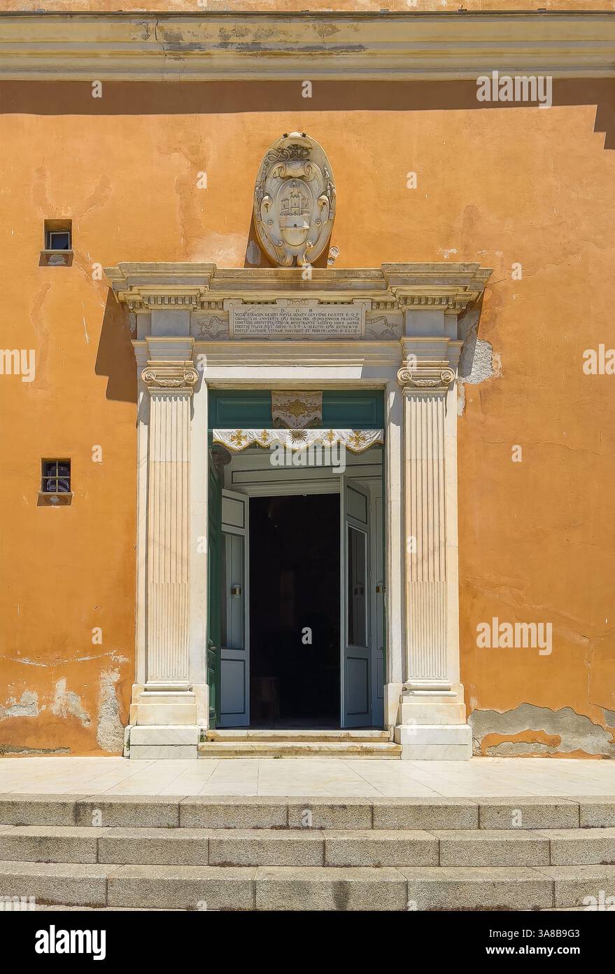 Ajaccio, Corsica, Francia 8 luglio 2024: Cattedrale di Santa Maria Assunta. Porta d'ingresso incorniciata da sculture in pietra di pilastri, stemma e testo Foto Stock