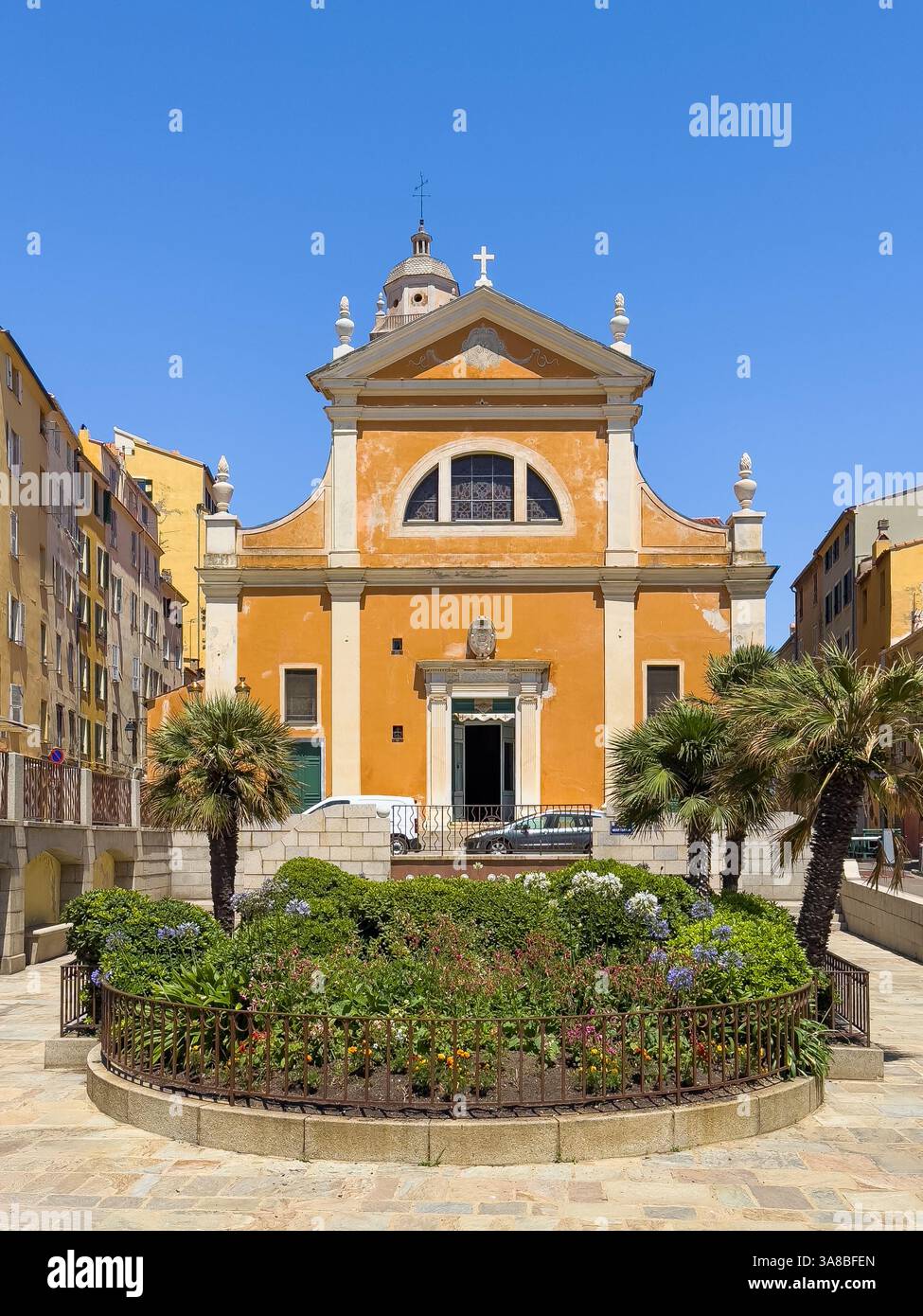 Ajaccio, Corsica, Francia 8 luglio 2024: Facciata anteriore della cattedrale di Santa Maria Assunta di colore marrone beige sotto il cielo blu. Vista dal giardino di Place Mère Teresa Foto Stock