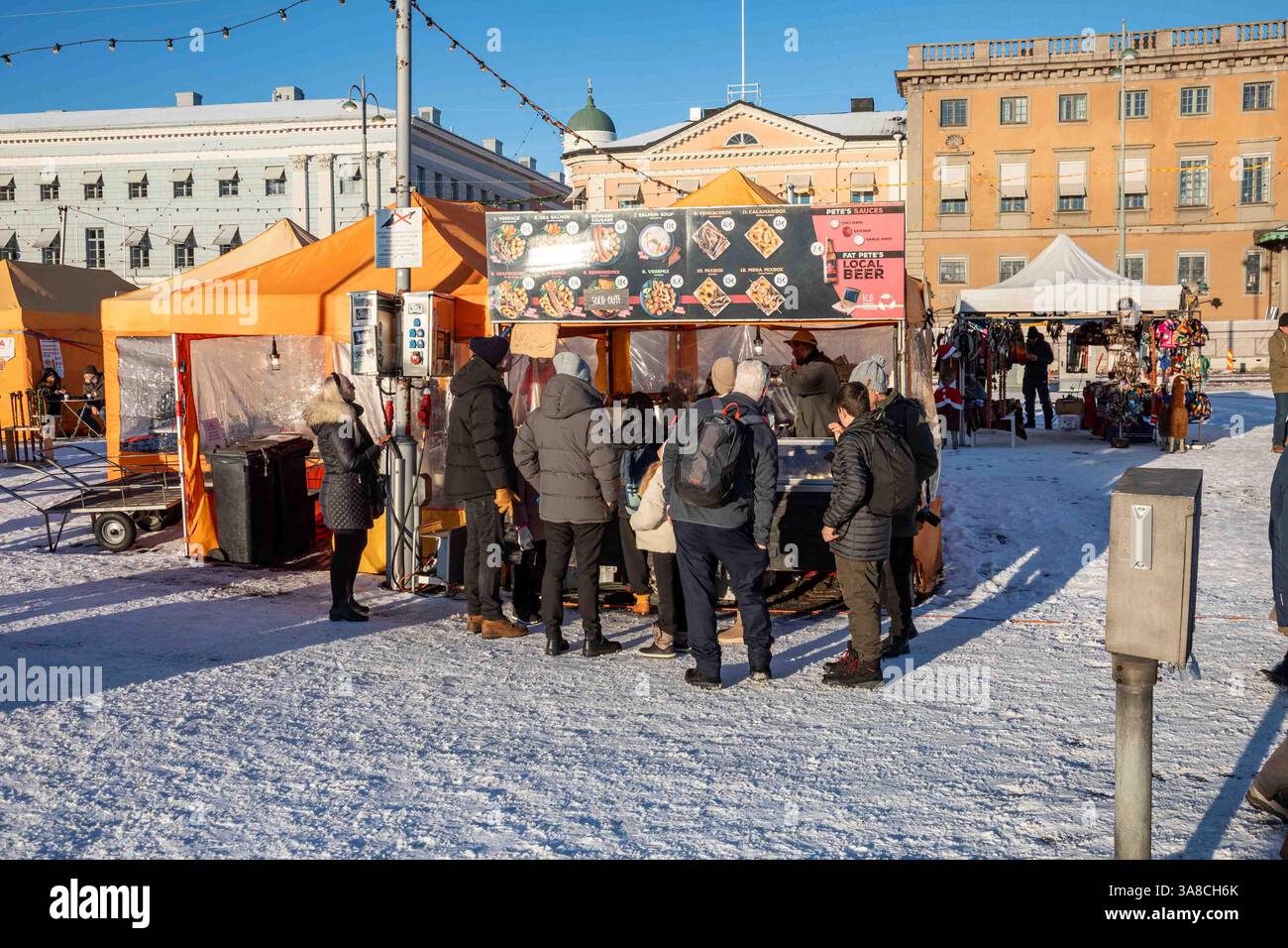 Gente in fila per il cibo di strada sulla piazza del mercato ricoperta di neve a Helsinki, Finlandia Foto Stock