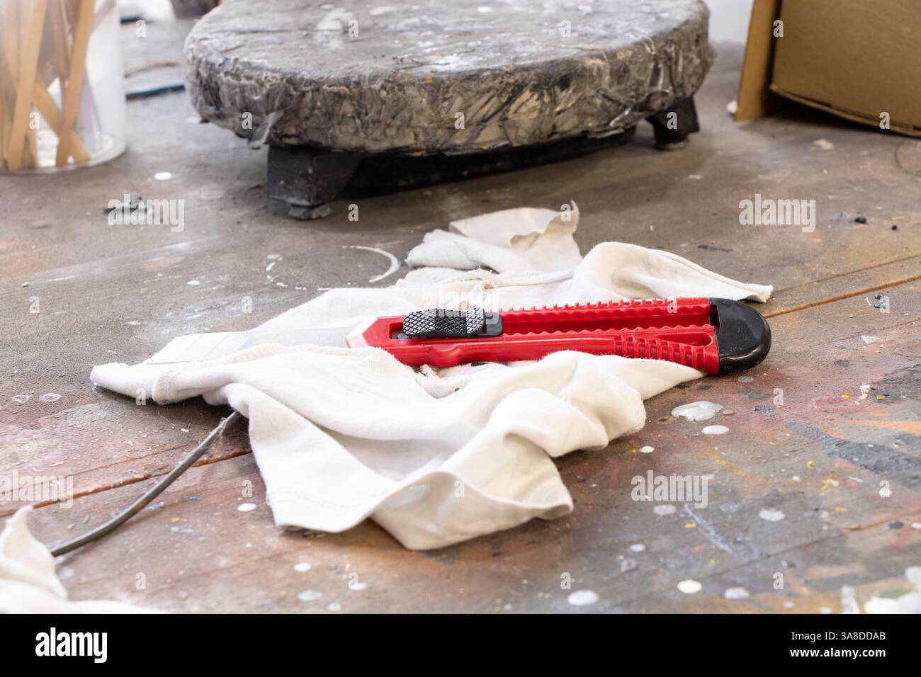 Il coltello da costruzione si trova su uno straccio in un'officina di un pittore su un tavolo di legno nella pittura, sul luogo di lavoro Foto Stock