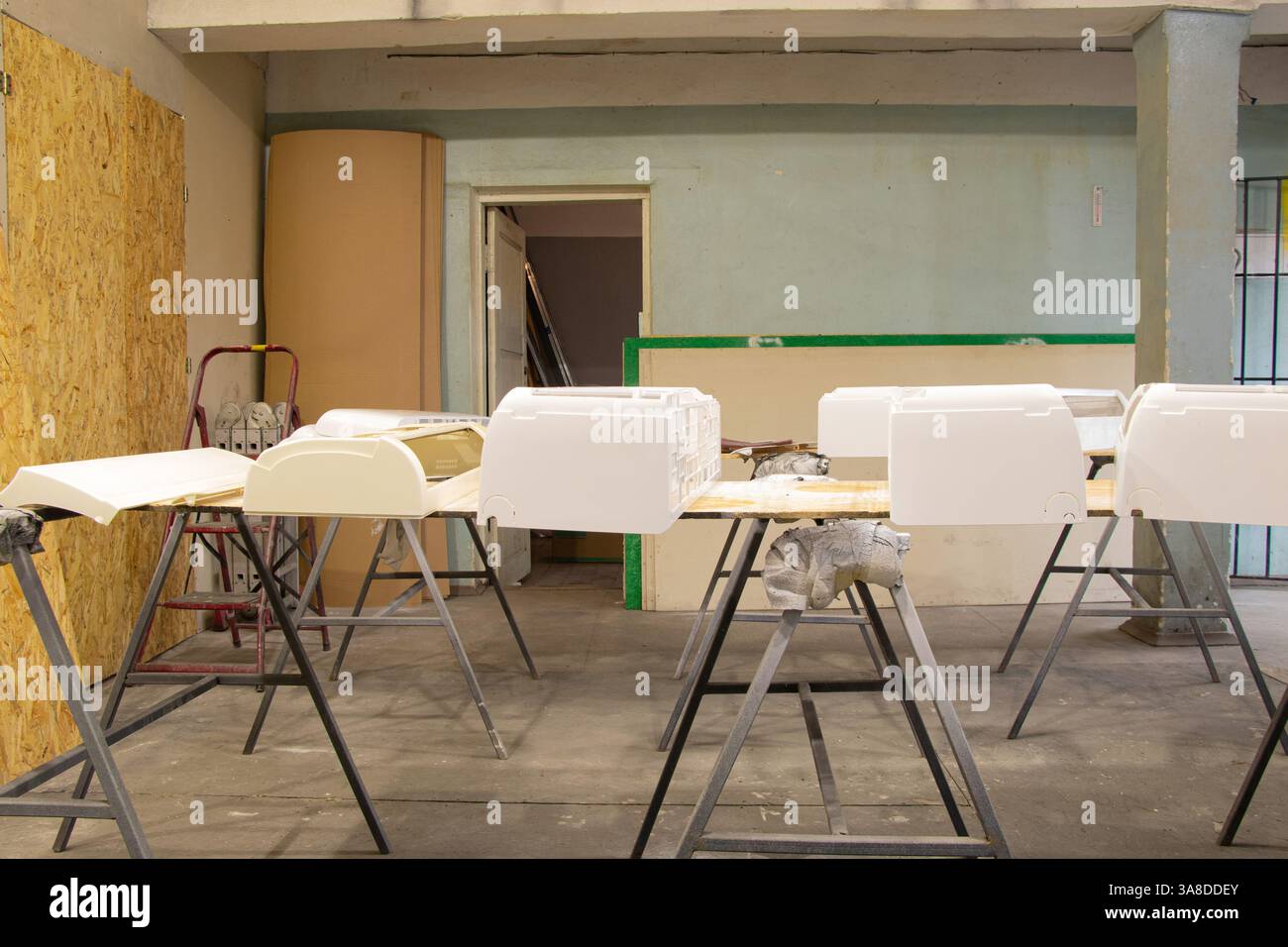 Officina di verniciatura, dove gli alloggiamenti del condizionatore d'aria sono disposti su tavoli per la verniciatura, officina Foto Stock