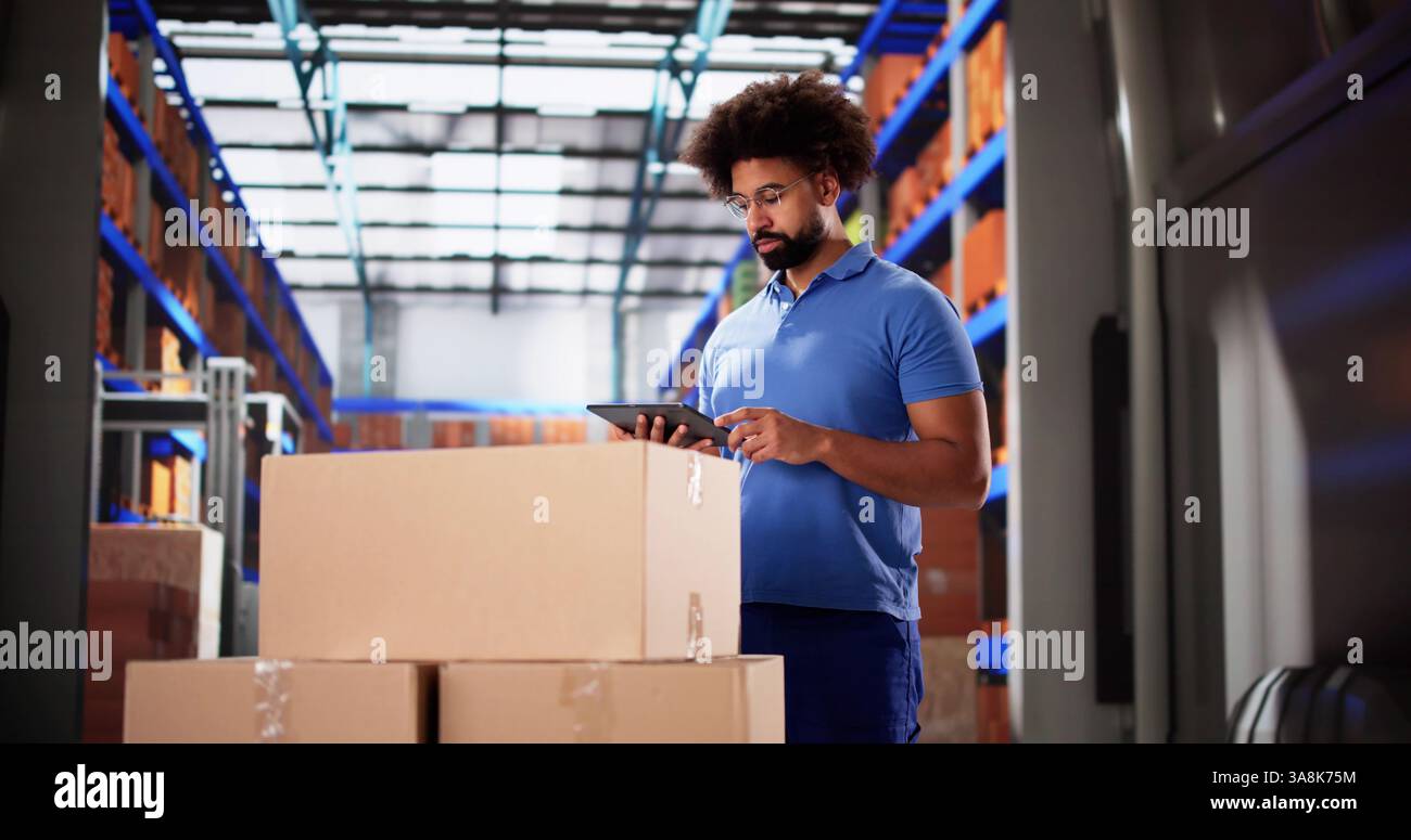 Addetto alle consegne nero sorridente mentre utilizza il tablet per il trasporto su camion Foto Stock