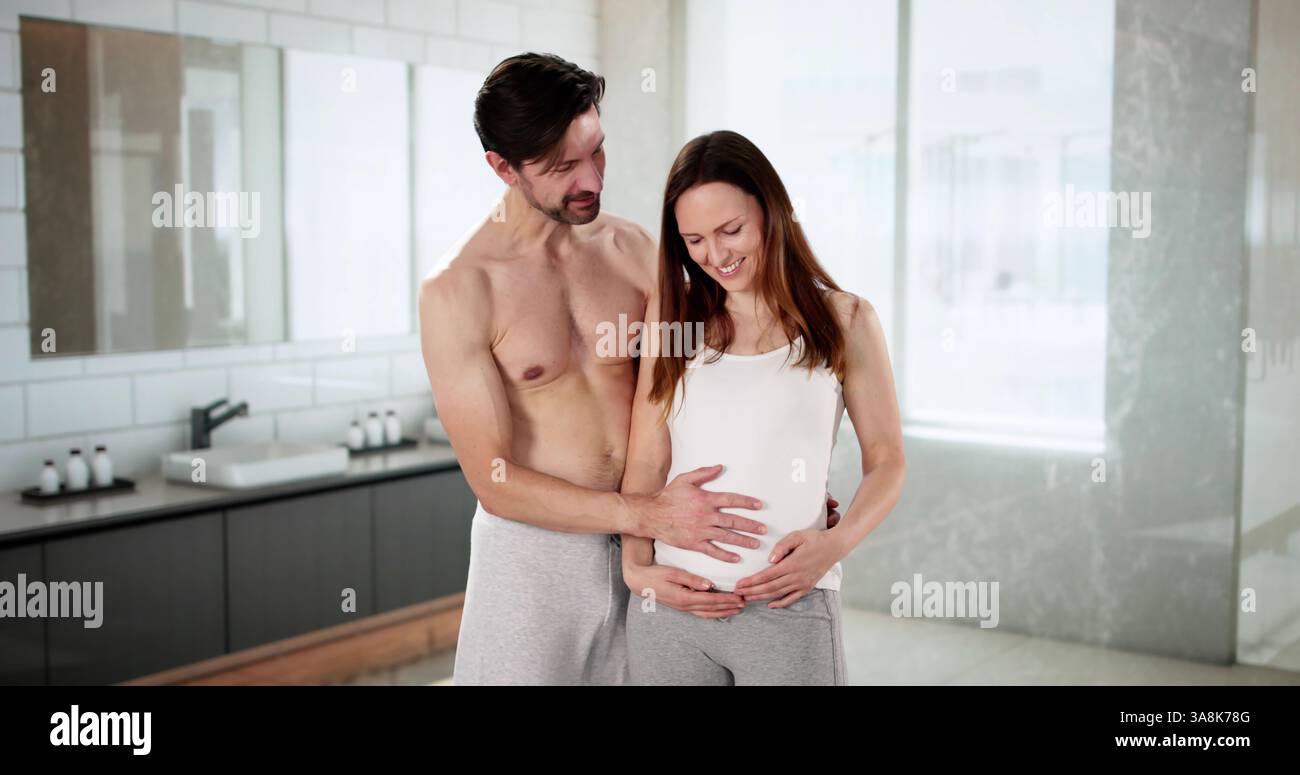 Coppia gioiosa che abbraccia insieme in un bagno luminoso. Foto Stock