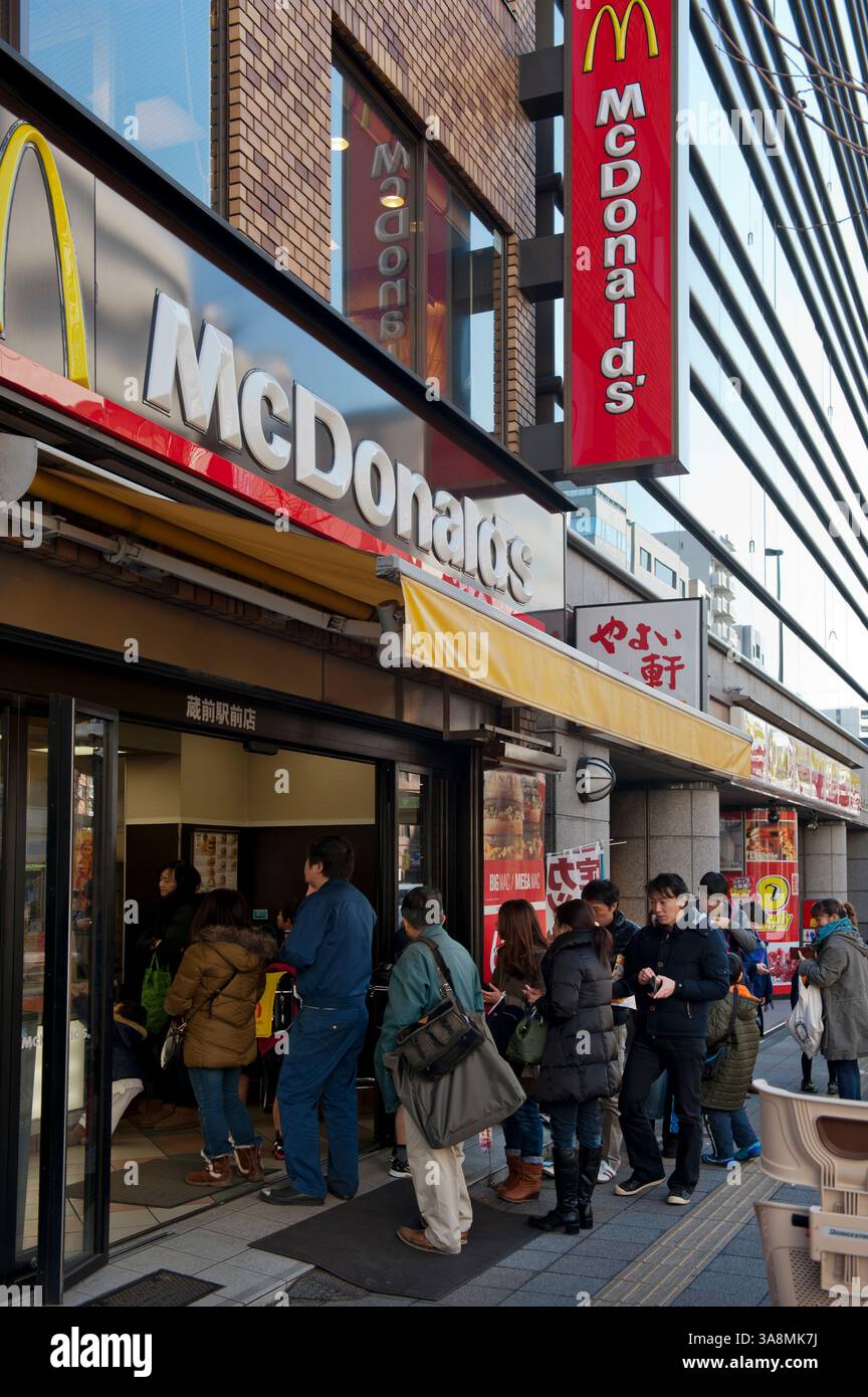 Una lunga fila di clienti che aspettano fuori da un fast-food americano McDonald's nel quartiere Asakusa di Tokyo, Giappone. Foto Stock