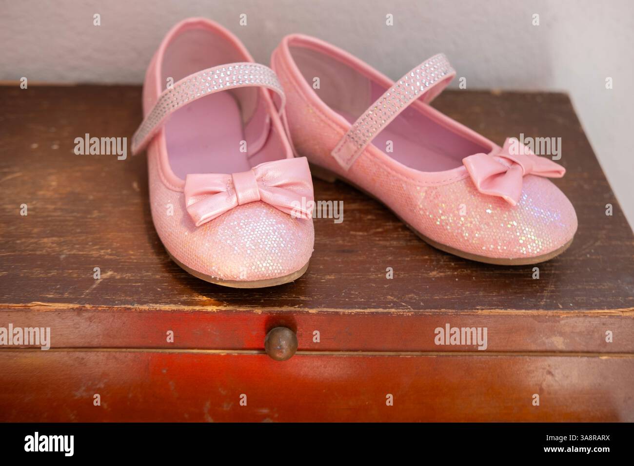 le scarpe rosa scintillanti con fiocchi simboleggiano l'individualità, l'autosufficienza e la determinazione a padroneggiare nuove abilità, la moda per bambini e ottenere l'indipendenza Foto Stock