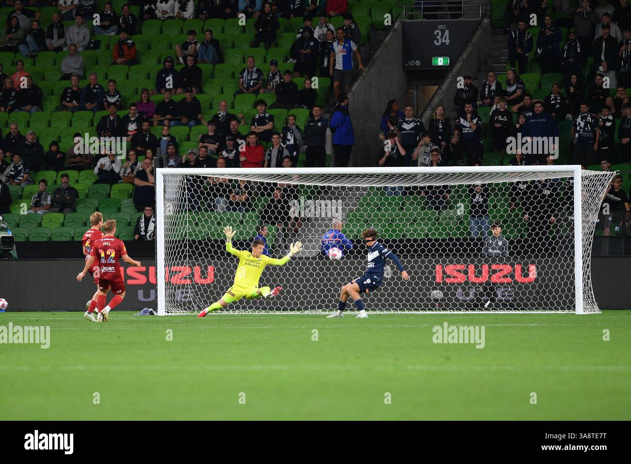 MELBOURNE, AUSTRALIA. 29 marzo 2025. Nella foto: Il centrocampista dell'Adelaide United Jonny YULL spara la palla davanti al portiere della Vittoria Mitch Langerak per aprire il punteggio al dodicesimo minuto per mettere Adelaide in vantaggio nel primo tempo durante la partita ISUZU A League Pride Cup Unite Round 24, Melbourne Victory vs Adelaide United all'AAMI Park di Melbourne, Australia il 29 marzo 2025. Crediti: Karl Phillipson / Alamy Live News Foto Stock
