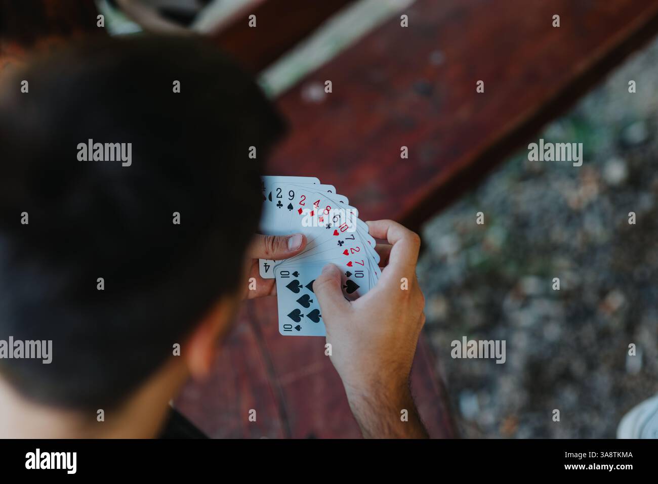Primo piano di una persona che tiene un mazzo di carte da gioco all'aperto Foto Stock
