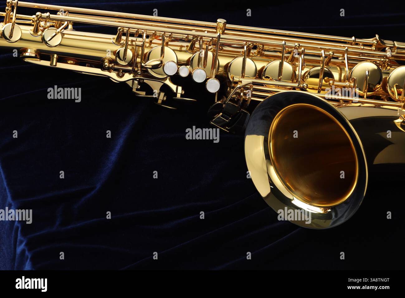 Jazz. Un bellissimo sassofono su tessuto blu scuro, primo piano. Spazio per il testo Foto Stock