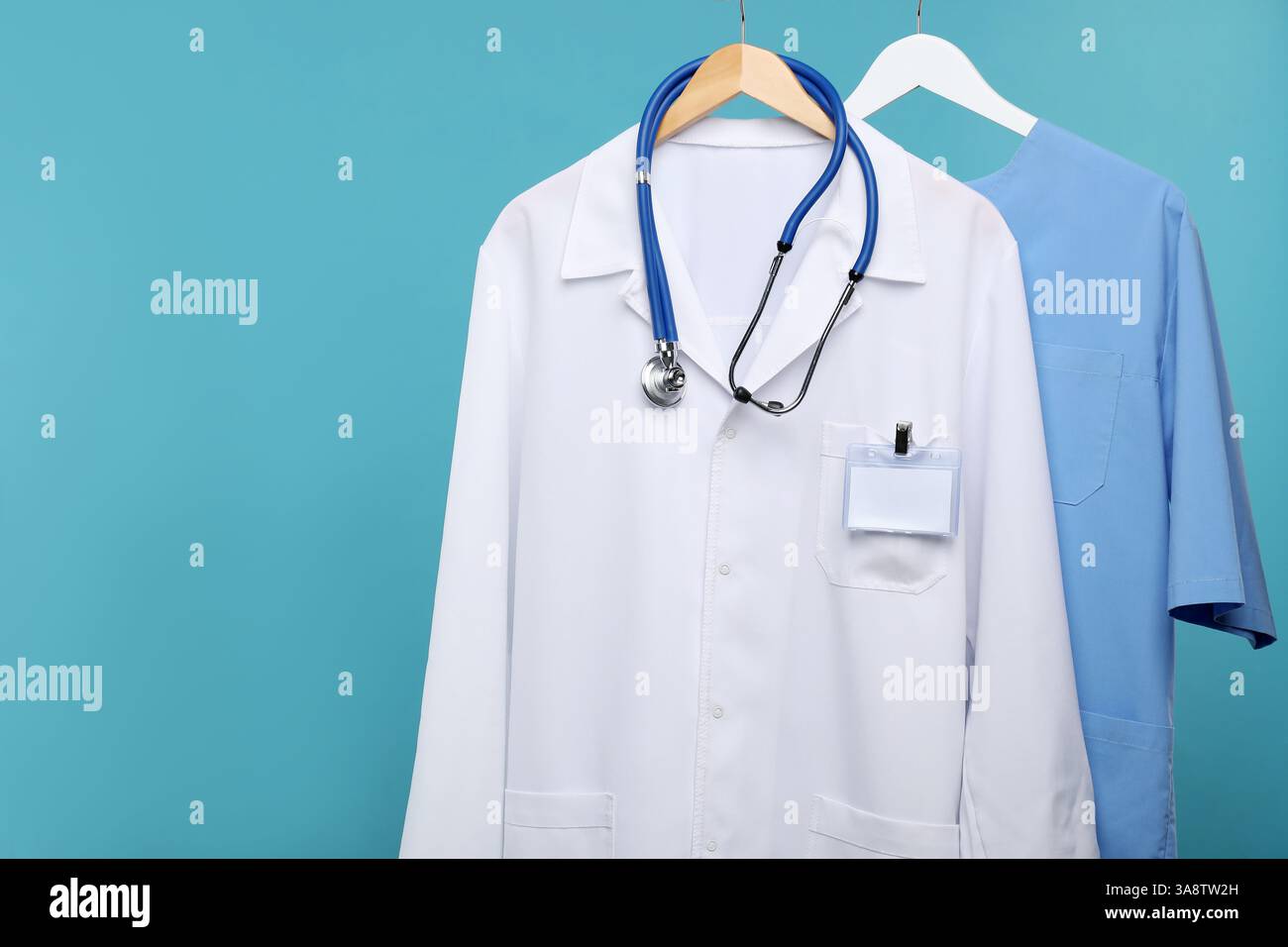 I lavoratori medici si uniformi con stetoscopio su grucce su sfondo blu Foto Stock