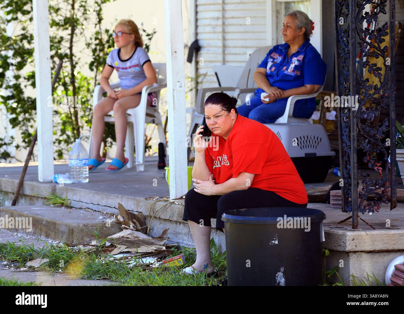 29 agosto 2017 - Woodsboro, TX, USA - Desiree Nesloney parla al telefono con un amico come Esther Pridgen, indietro a sinistra, e Olga Tanguma, destra, si siedono fuori dopo che l'uragano Harvey ha distrutto la loro casa, martedì 29 agosto 2017, a Woodsboro, Texas. (Immagine di credito: © Gabe Hernandez/TNS via ZUMA Wire) Foto Stock