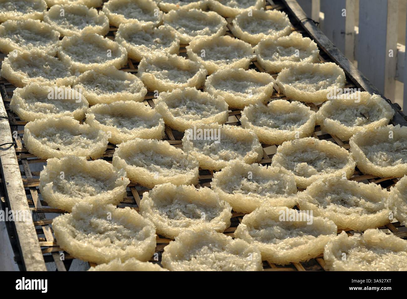 Torte di riso rotonde appiccicose che si asciugano su una griglia di bambù di fronte a un wat, Luang Prabang, Laos, Asia Foto Stock