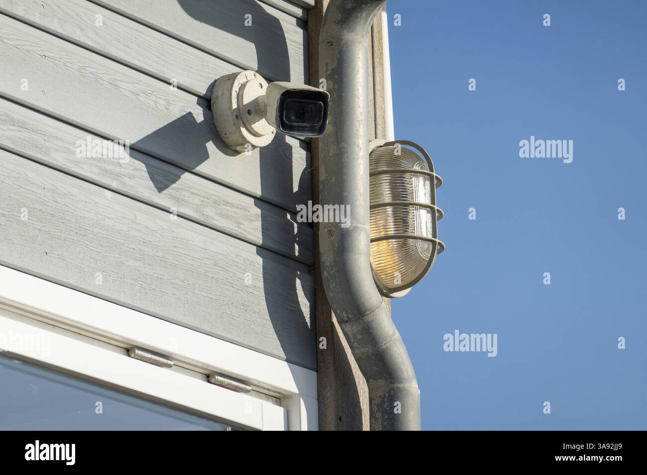 Telecamera di sorveglianza e luce esterna che garantiscono la sicurezza e la sicurezza di un edificio contemporaneo Foto Stock
