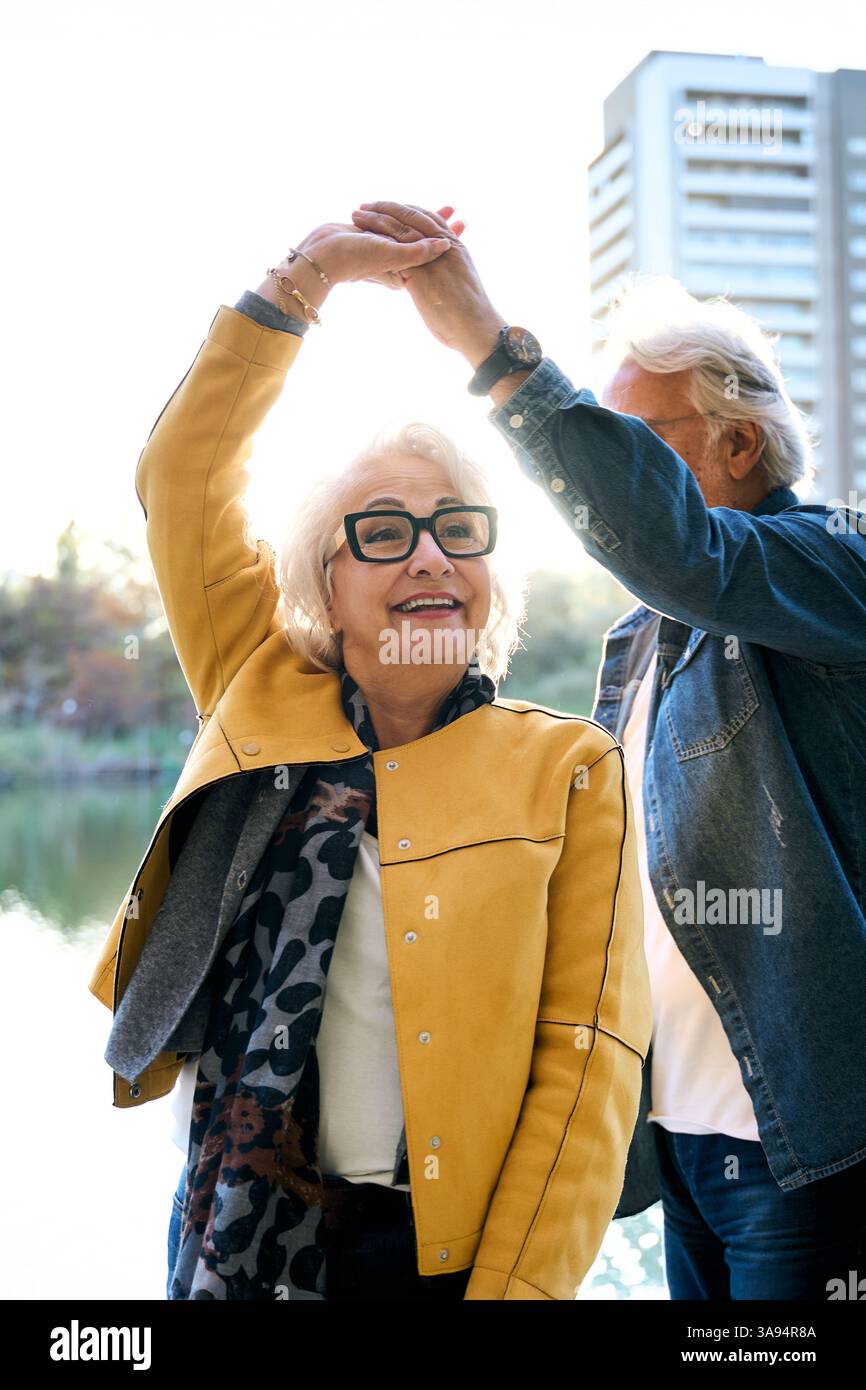 Felice coppia senior che balla sul lago in città Foto Stock