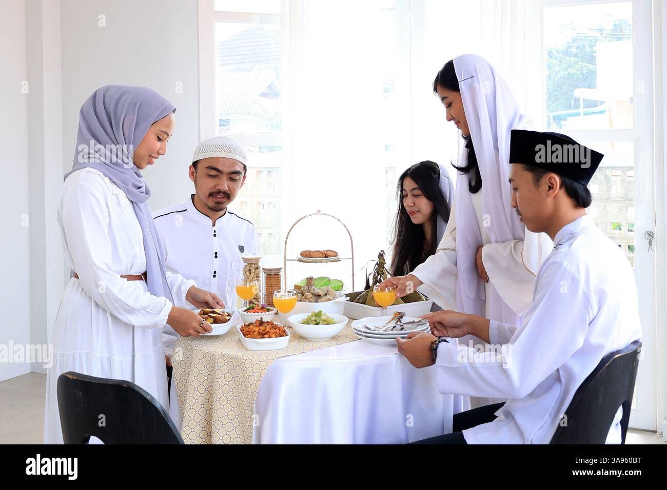 Colazione con la famiglia e gli amici per la celebrazione Eid al Fitr con Ketupat e altri piatti Lebaran Foto Stock