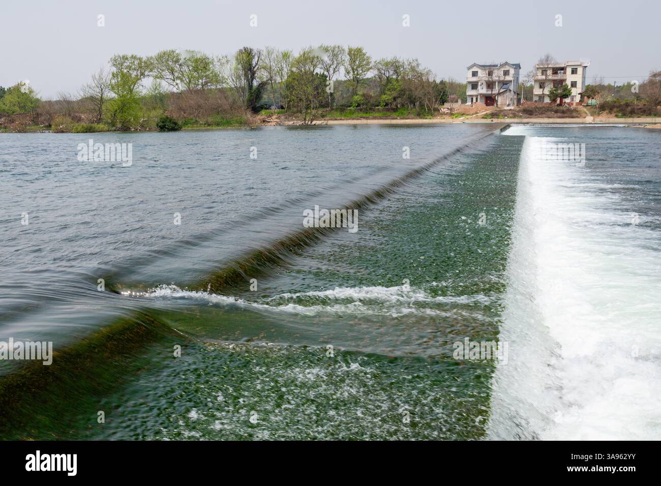 Serenity a cascata: Il dolce flusso di una cascata rurale attraverso la vegetazione lussureggiante - Sinfonia d'acqua pacifica della natura Foto Stock