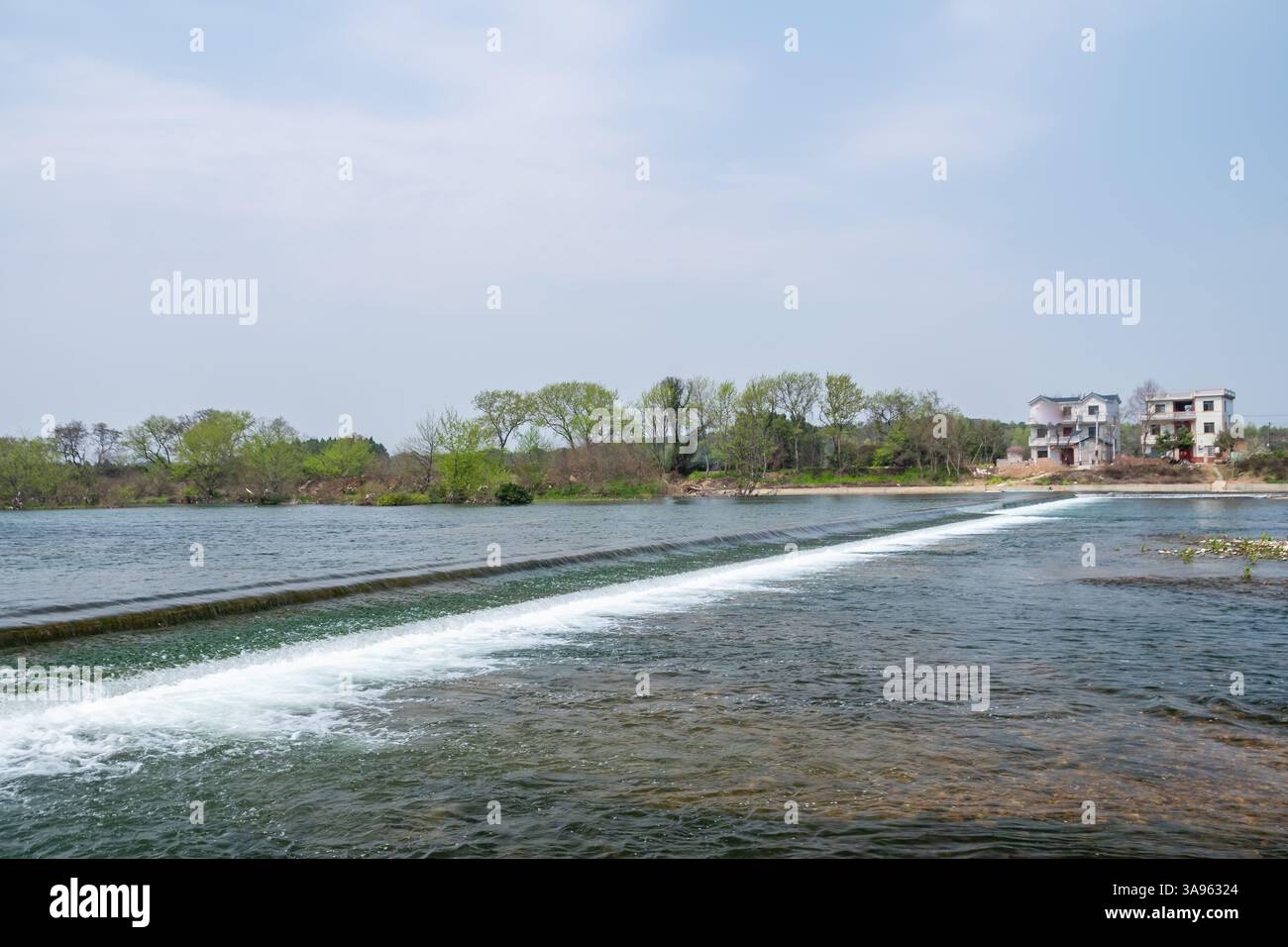 Serenity a cascata: Il dolce flusso di una cascata rurale attraverso la vegetazione lussureggiante - Sinfonia d'acqua pacifica della natura Foto Stock