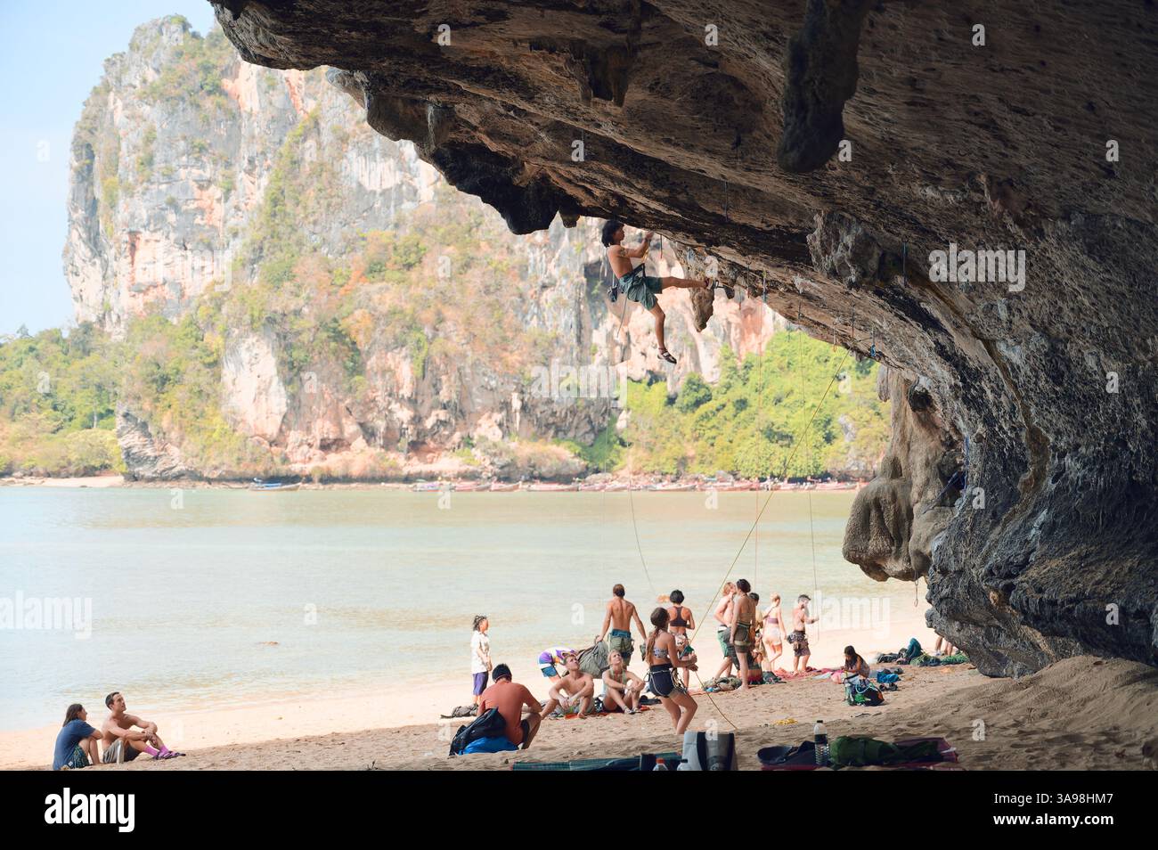 L'arrampicatore è appeso su un ripido sbalzo calcareo, osservando sotto la spiaggia di Tonsai Foto Stock