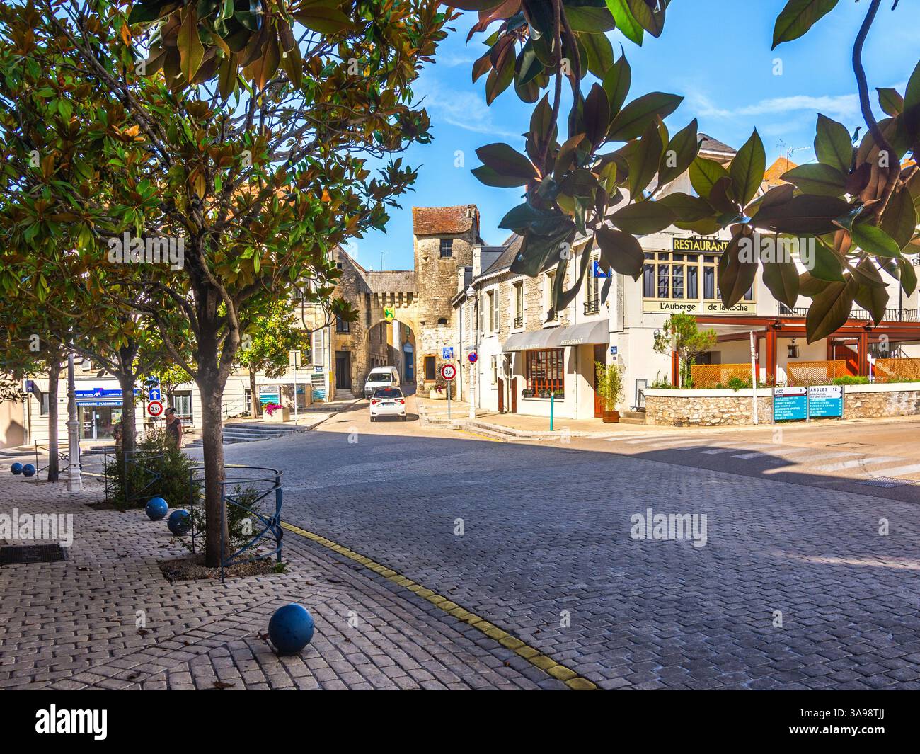 Vista lungo la Rue Bourbon alberata verso il vecchio portale d'ingresso verso la città di la Roche Posay, Vienne (86), Francia. Foto Stock