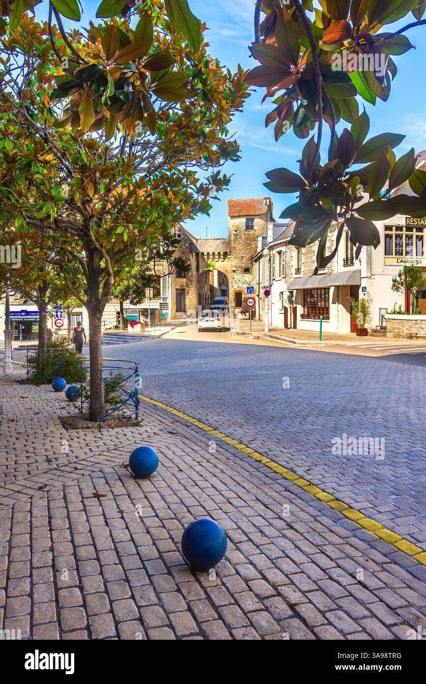 Vista lungo la Rue Bourbon alberata verso il vecchio portale d'ingresso verso la città di la Roche Posay, Vienne (86), Francia. Foto Stock