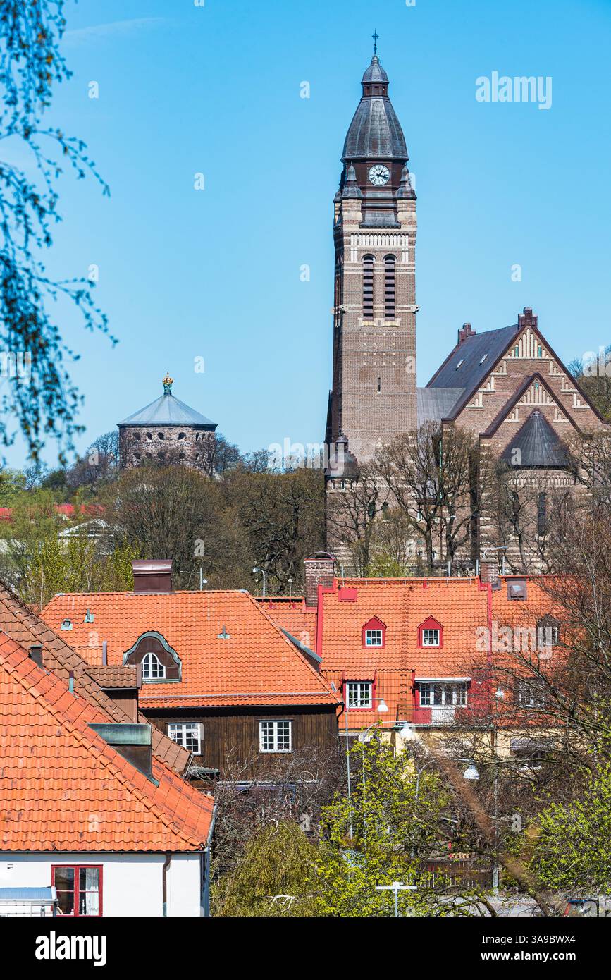 Una chiesa prominente si erge su di un cielo blu luminoso, circondata da affascinanti case tradizionali con tetti rossi. La scena cattura l'essenza di Foto Stock
