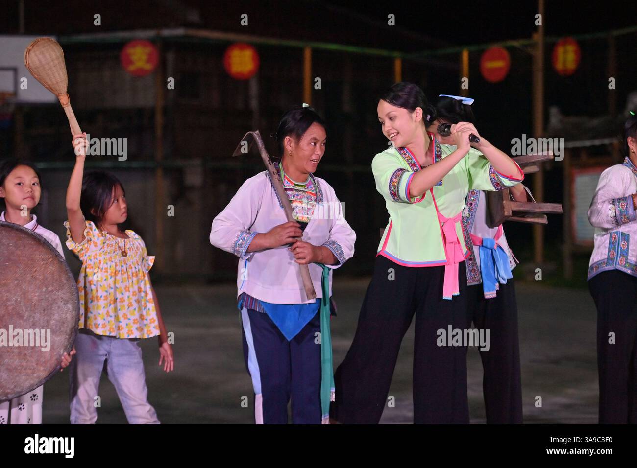 (250330) -- RONGSHUI, 30 marzo 2025 (Xinhua) -- Un insegnante istruisce gli abitanti del villaggio in una dimostrazione del patrimonio culturale immateriale in una scuola serale nel villaggio di Wuying al confine tra la regione autonoma Guangxi Zhuang della Cina meridionale e la provincia di Guizhou della Cina sud-occidentale, 9 agosto 2024. Dal 2017, con il sostegno di un programma di assistenza in coppia, le autorità locali hanno continuamente migliorato l'ambiente di vita e le strutture culturali del villaggio di Wuying, con l'obiettivo di rafforzare l'eredità e lo sviluppo della cultura etnica e promuovere la rivitalizzazione rurale. (Xinhua/Huang Xiaobang) Foto Stock