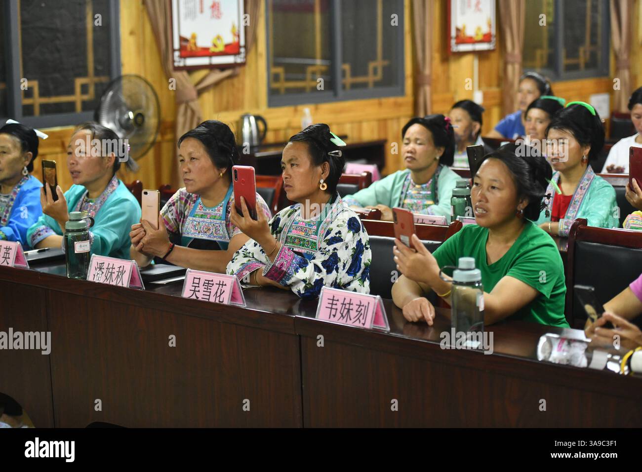(250330) -- RONGSHUI, 30 marzo 2025 (Xinhua) -- donne che cantano canzoni etniche Miao in una scuola serale nel villaggio di Wuying al confine tra la regione autonoma Guangxi Zhuang della Cina meridionale e la provincia di Guizhou della Cina sud-occidentale, 11 agosto 2020. Dal 2017, con il sostegno di un programma di assistenza in coppia, le autorità locali hanno continuamente migliorato l'ambiente di vita e le strutture culturali del villaggio di Wuying, con l'obiettivo di rafforzare l'eredità e lo sviluppo della cultura etnica e promuovere la rivitalizzazione rurale. (Xinhua/Huang Xiaobang) Foto Stock