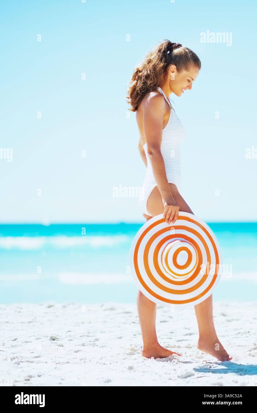 giovane donna con cappello sulla spiaggia Foto Stock