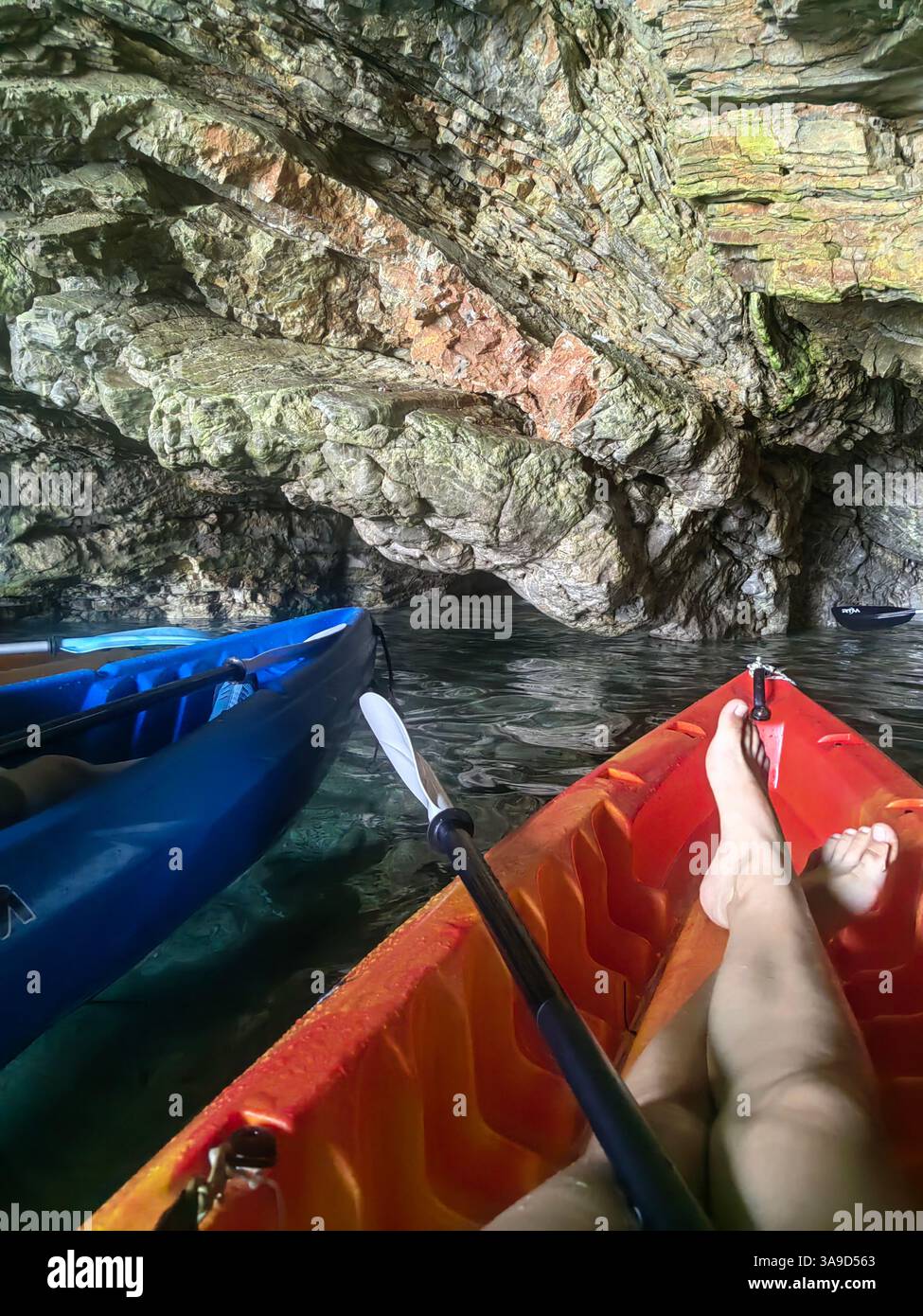 Kayak all'interno di una grotta marina: Viaggi avventurosi, esplorazione della natura e attività ricreative all'aperto Foto Stock