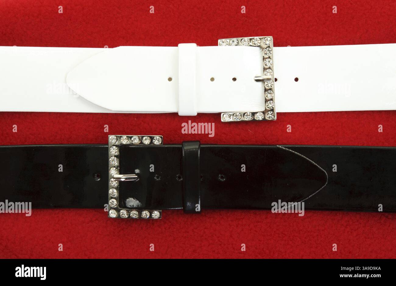 Due cinghie di cuoio su tessuti rosso sfondo Foto Stock