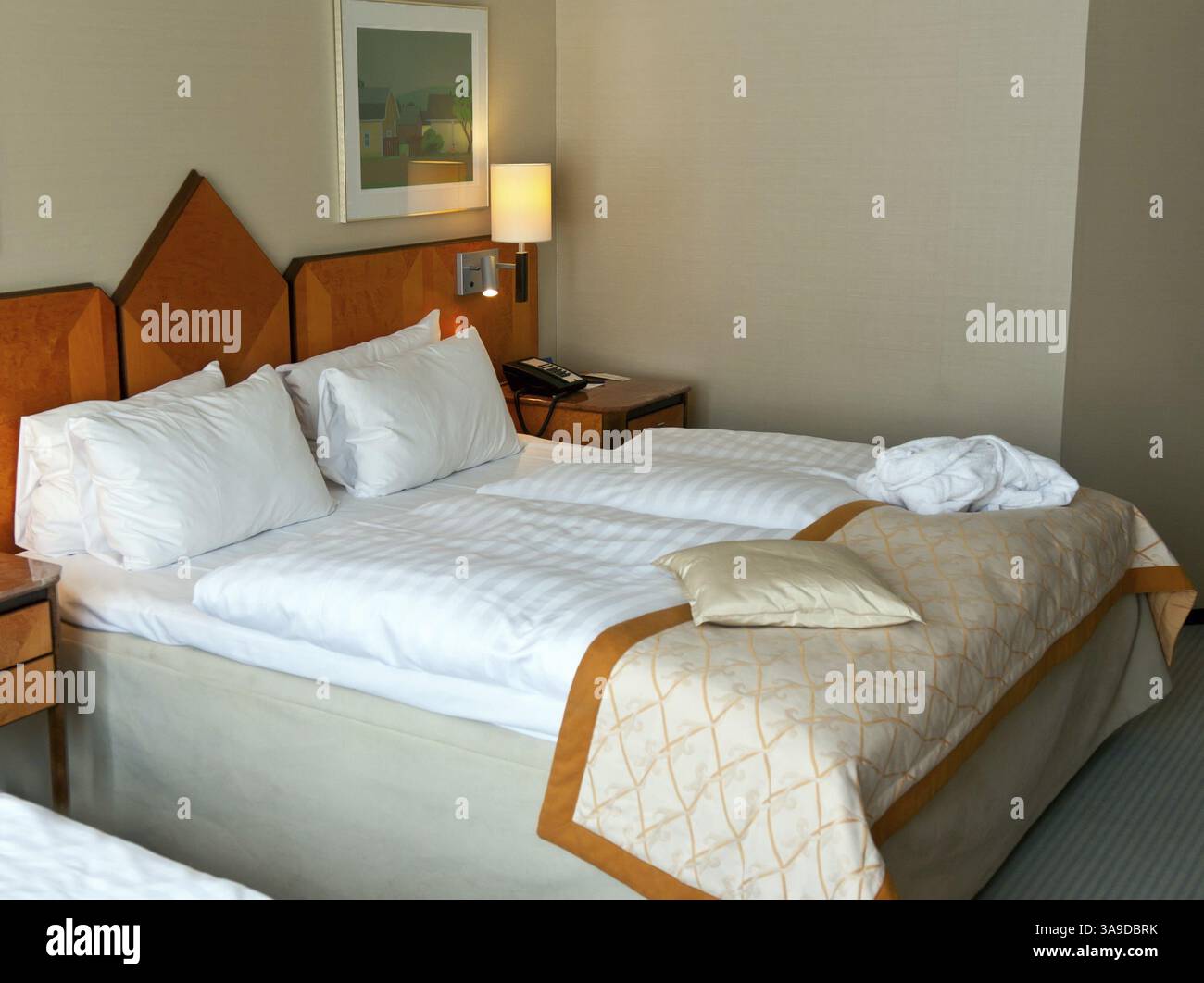 Letto in una camera d'hotel con comodini Foto Stock