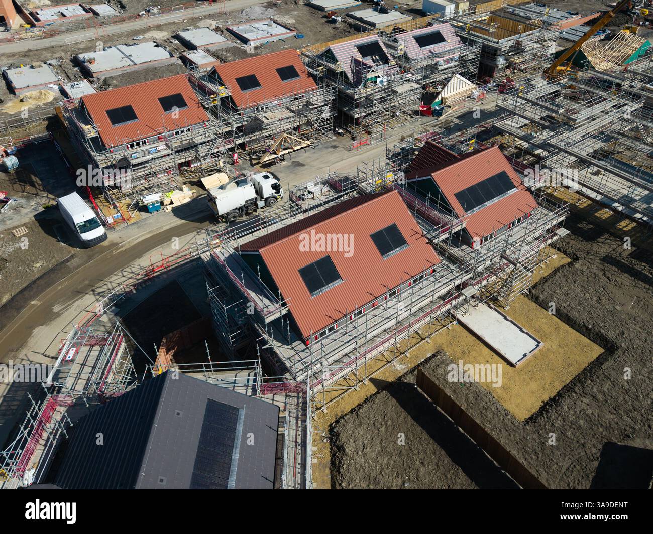 Il tetto di una nuova costruzione ospita in costruzione in un cantiere con tetto integrato o pannelli solari sul tetto per un'energia economica e sostenibile Foto Stock