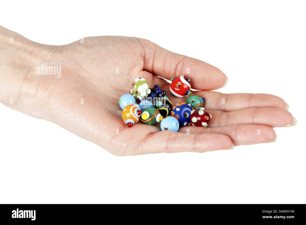 Vetro colorato di perline in una femmina di mano su uno sfondo bianco Foto Stock