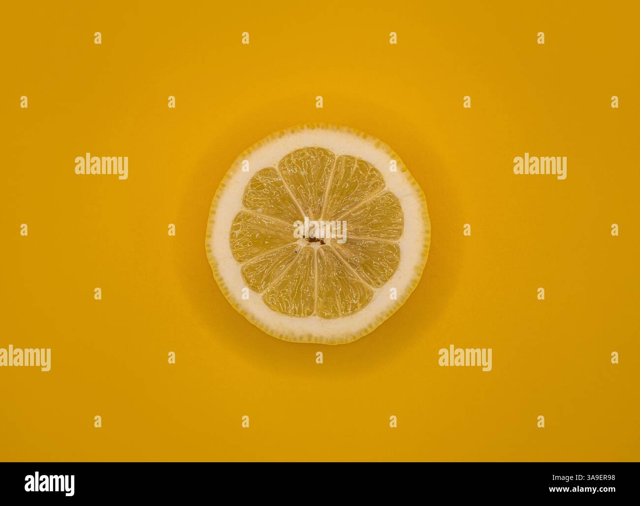 Una fetta di limone fresca su un vivace sfondo giallo. Foto Stock