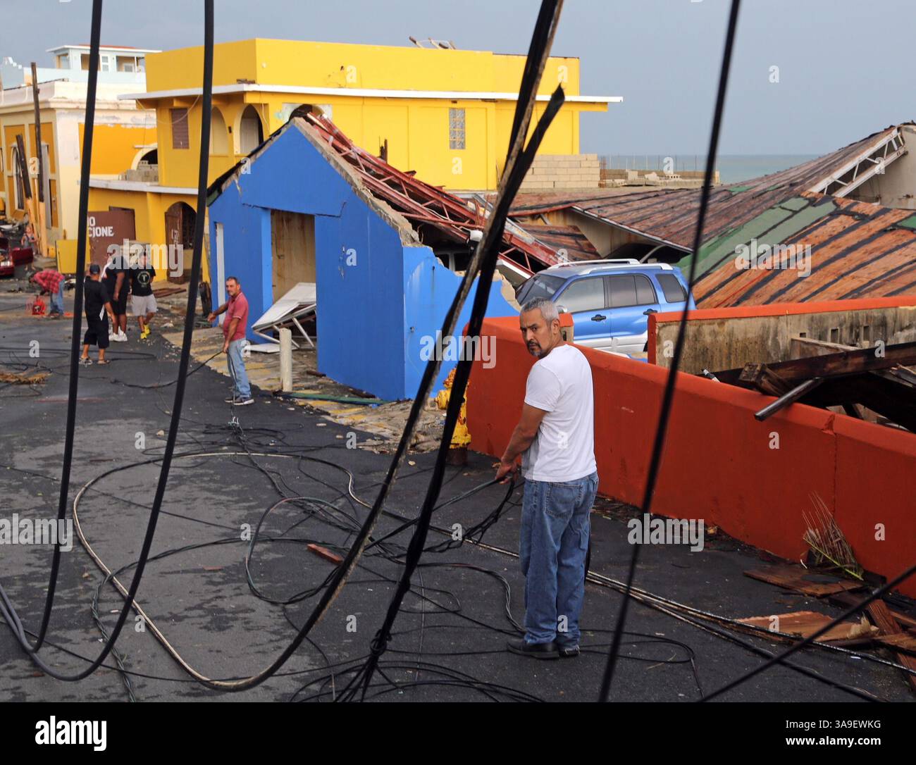 21 settembre 2017 - San Juan, Porto Rico - l'uomo trascina le linee elettriche mentre i residenti del quartiere ''la Perla'' di San Juan hanno preso in mano il recupero dell'uragano mentre iniziano il difficile compito di ripulire a causa della paura di essere dimenticati dal governo. L'uragano Maria ha lasciato molte strade di San Juan inondate e bloccate da linee elettriche cadute, alberi e detriti mentre Puerto Rico cerca di riprendersi dalla tempesta di categoria 4. (Immagine di credito: © Carl Juste/Miami Herald tramite ZUMA Wire) Foto Stock