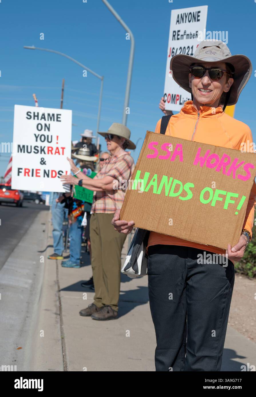 Manifestanti con cartelli che deridono Elon Musk e le buffonate DEL DOGE dell'amministrazione Trump, nonché cartelli con anti-TESLA, presso la concessionaria Tesla di Tucson, Arizona Foto Stock